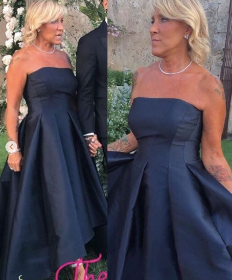 La madrina de la boda y madre de fedez ha escogido un diseño en palabra de honor color azul noche que ha combinado con unas sandalias de pulsera plateadas.