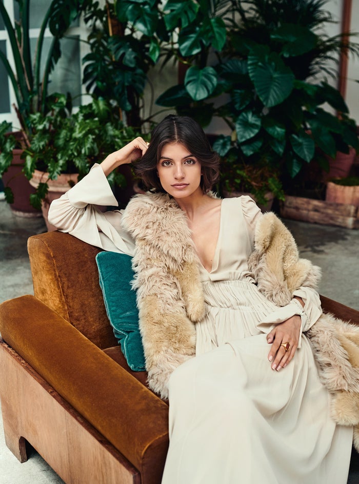 Nuria Rothschild luce vestido largo fruncido a la cintura y chaleco de Stella McCartney. Los anillos son de Grassy.