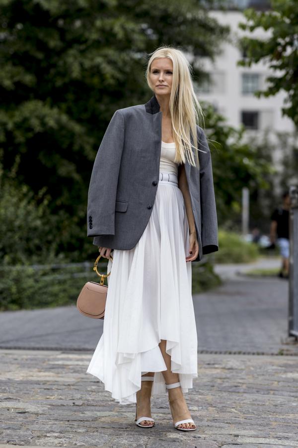 Otro ejemplo (maravilloso) más de cómo reutilizar tus prendas de verano en otoño. Este conjunto en blanco con falda asimétrica queda perfecto con una blazer sobria en gris.