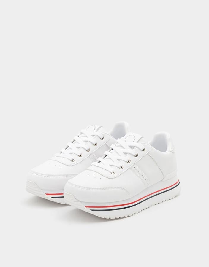 'Sneakers' en color blanco con plataforma y detalle de líneas de color, 29,99 euros.
