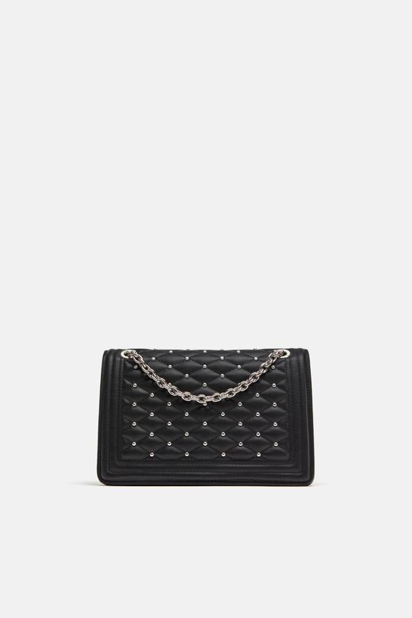 Las tachuelas del bolso acolchado lo han sacado varias firmas de lujo, como Chanel. Zara lo tiene por 49,95 euros.