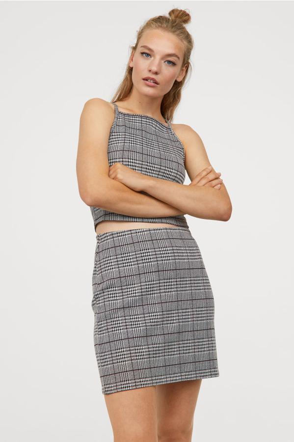 Falda corta de punto y con estampado de cuadros, 9,99 euros.