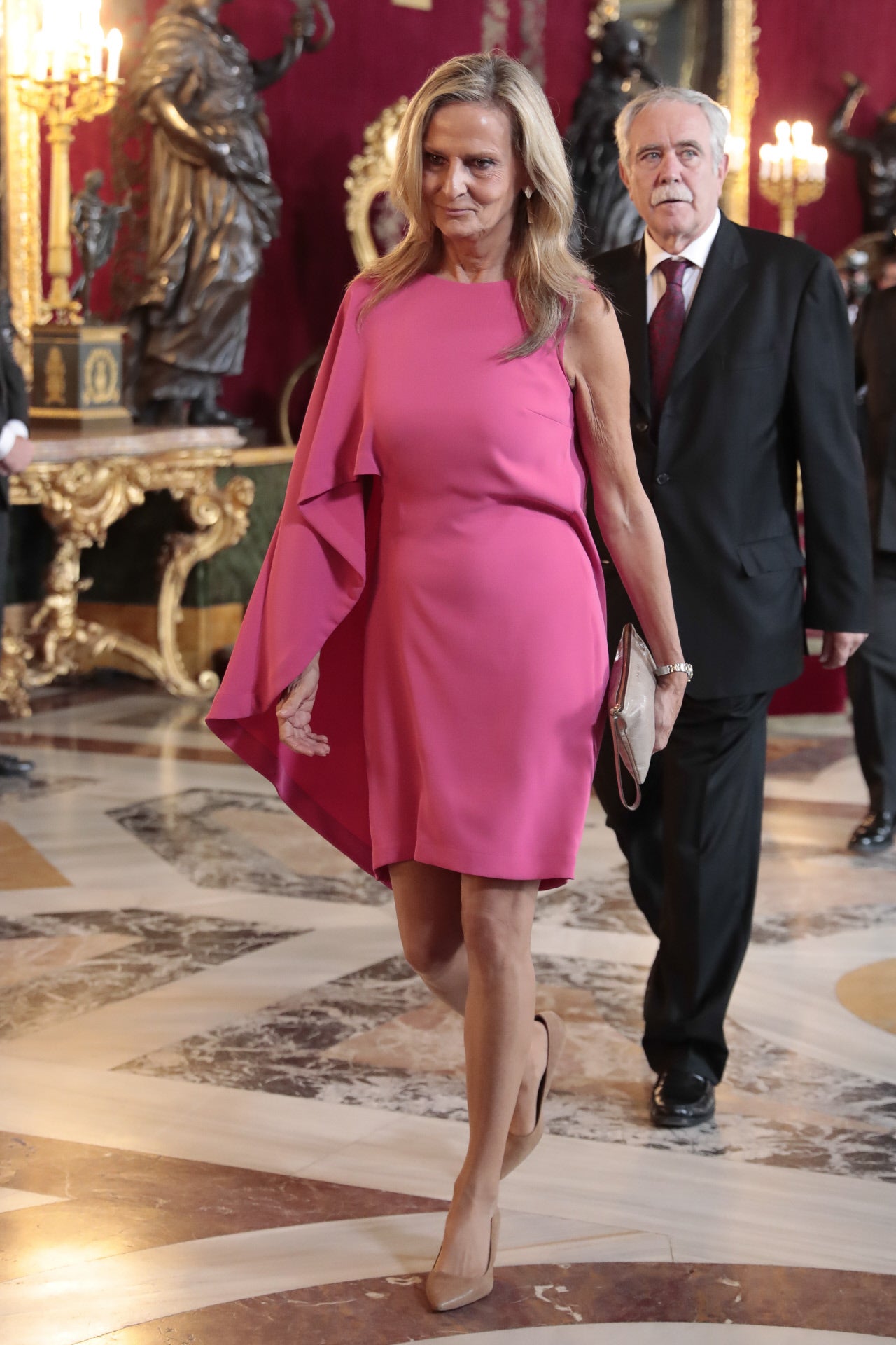 Isabel San Segundo, con un vestido asimétrico de color rosa chicle que ha combinado con un bolso de mano y unos zapatos de tacón bajo en color beige.
