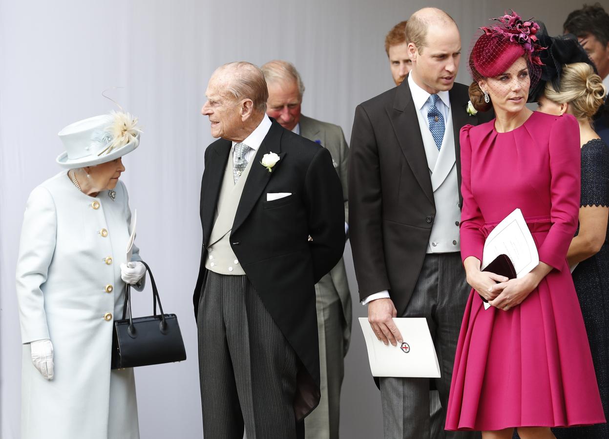 La reina Isabell II ha acudido a la bodade su nieta apostando por el color azul pastel mientras que Kate Middleton prefería resaltar con un fucsia apagado de Alexander McQueen. Ambas han acompañado su look con un tocado.