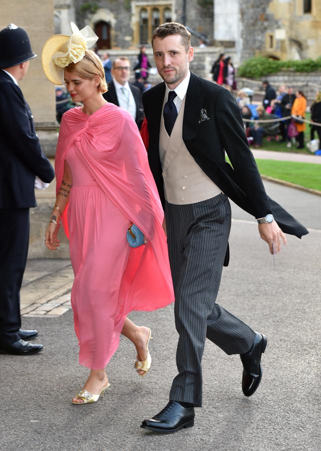 La modelo y cantante británica Pixie Geldof ha acudido a la ceremonia acompañada de su marido George Barnett. Con vestido y capa de color rosa chicle, contrastaba su look con un bolso color azul turquesa y unas sandalias de tacón destalonadas en color amarillo pastel a juego con su pamela.