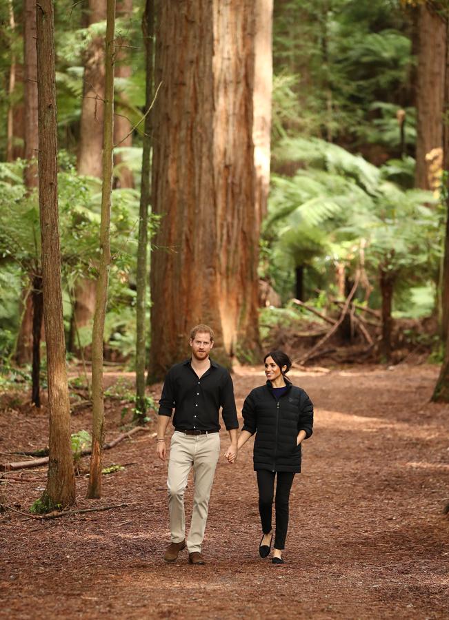 Para pasear por el Redwoods Tree Walk de Rotorua, en Nueva Zelanda, Meghan Markle volvió a apostar por un look 'sporty', esta vez en tonos negros, con una parka masculina (¿ella también le 'roba' la ropa a su chico?) de Oslo, sus pitillo de Outland Denim y unos slippers de Birdies.