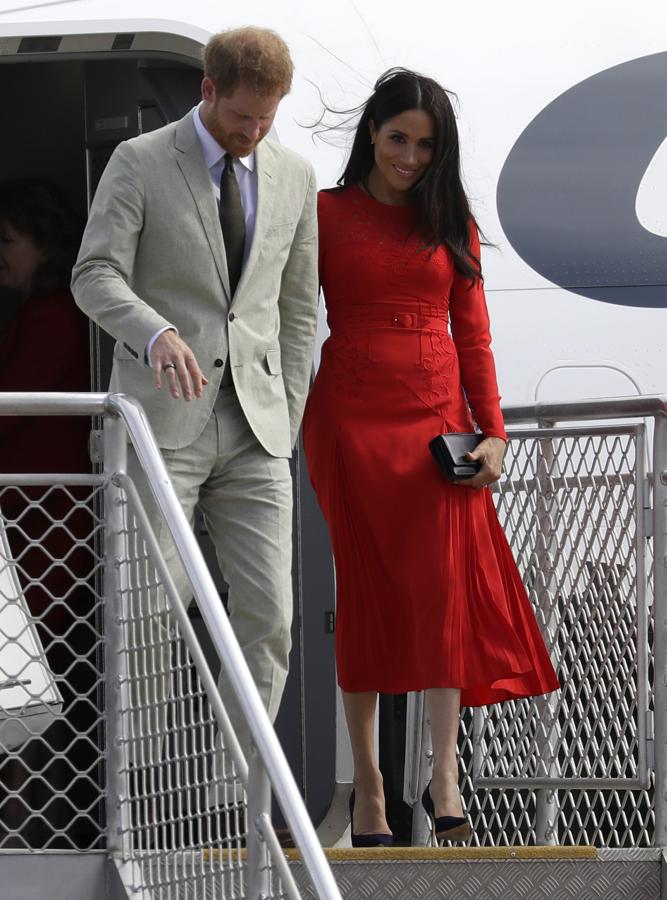 Los Duques de Sussex ya están en un nuevo destino en su periplo por Oceanía, y para su llegada a Tonga, Meghan Markle ha apostado por un vestido hiperfemenino en rojo con detalle de bordados y cinturón de Self Portrait. Eso sí, tiene un detalle que nos ha dejado con los ojos como platos...