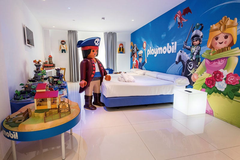Soñar jugando. ¿Por qué nos gusta? Porque el Hotel del Juguete de Ibi tiene habitaciones temáticas de sus muñecos favoritos, desde Barriguitas hasta Playmobil, ludoteca y clases de cocina. DÓNDE: en Ibi, a 35 minutos de Alicante. Cuánto: Dos adultos y un niño, desde 150 €.