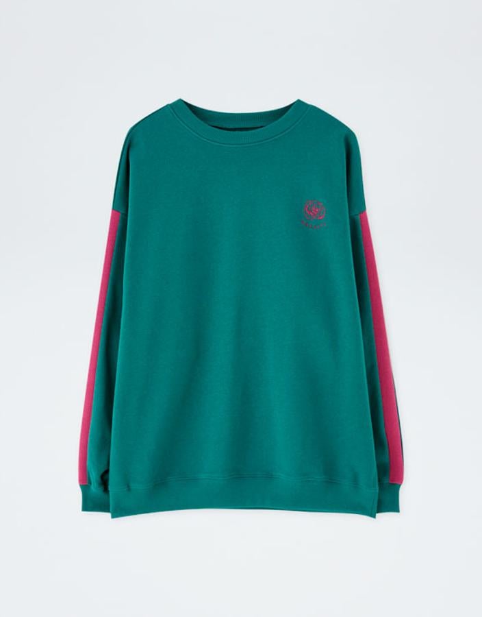 Fantástica sudadera esta vez larga que contrasta el verde profundo con detalles (las cintas laterales, una flor y el nombre de la cantante) en fúcsia (22,99 euros).
