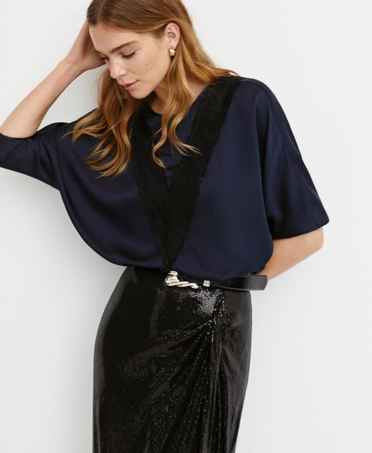 La blusa con tejido satinado, paneles de encaje, cuello redondo, manga larga y escote en pico en la parte posterior aún está disponible en Mango y su precio es de 35,99 euros.