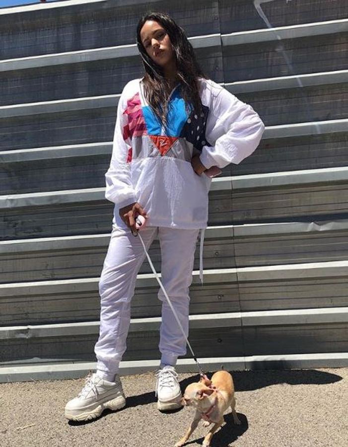 En blanco y tejido impermeable para pasear a su perrito. No le faltan sus zapatillas favoritas: blancas y con plataforma.