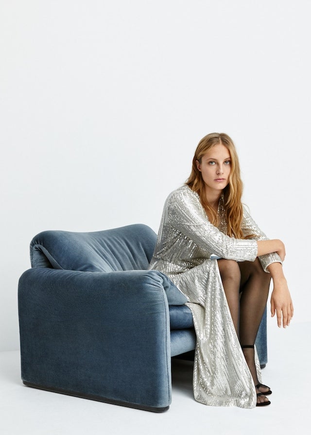 Un diseño extremadamente sencillo, con escote en pico y abertura frontal, para que toda la atención se la lleve el tejido cuajado de lentejuelas plateadas (Mango, 99,99 euros).