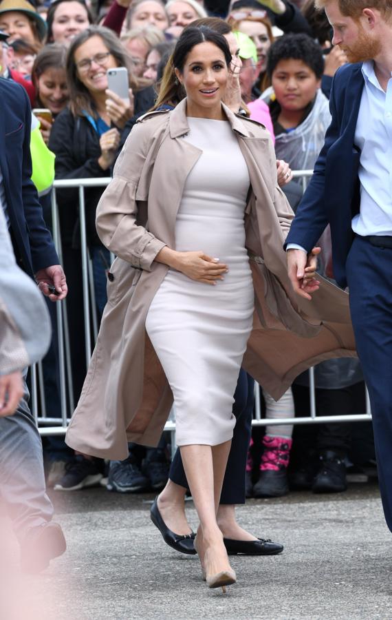 En esta ocasión Meghan lleva un vestido de corte midi en color crudo, otro de los grandes asiduos de Meghan y de escote tipo barco.