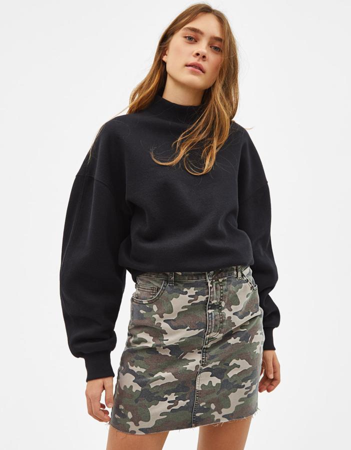 Genial conjunto con una sudadera básica y una minifalda vaquera con el camuflaje estampado con un efecto desgastado (17,99 euros).