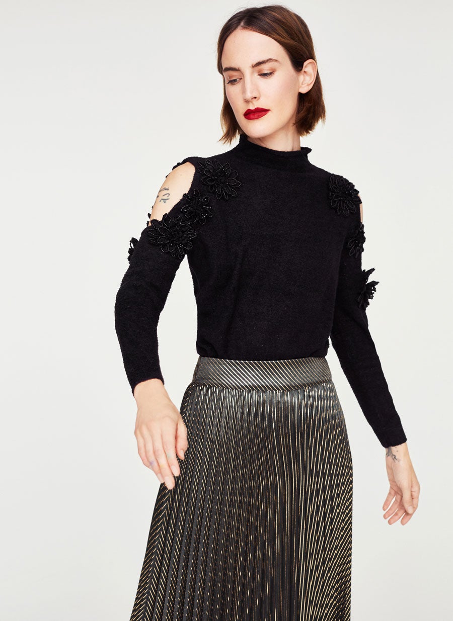 La versión más elegante del jersey con aberturas es esta de Uterqüe. Es de punto, con el cuello redondo y el detalle de flores con pedrería le da el toque final. (99 euros).