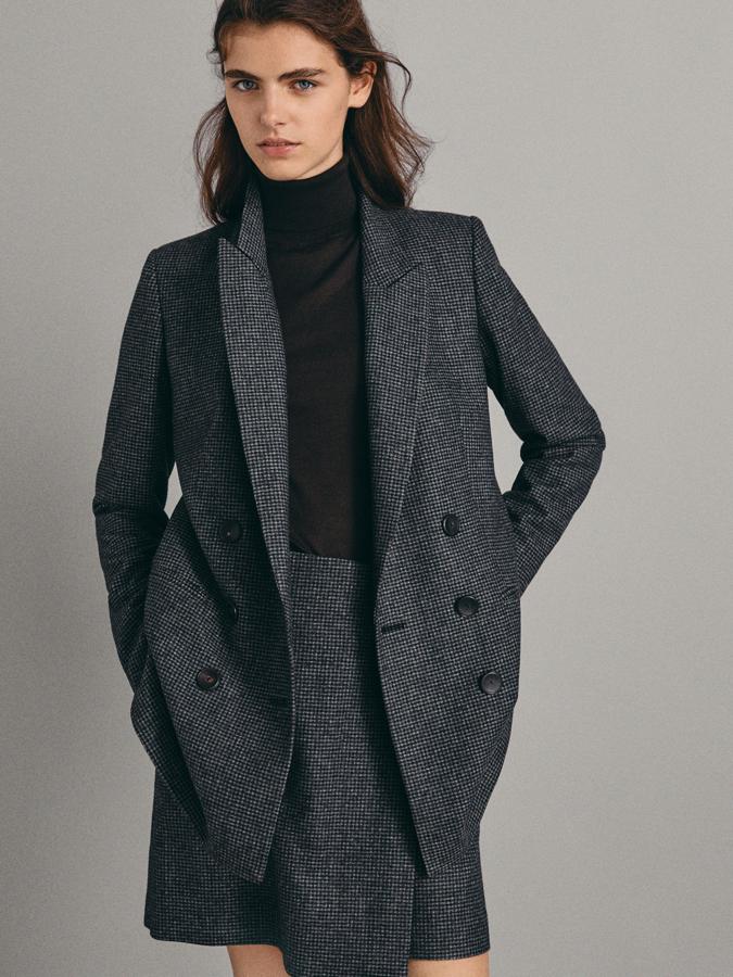 Americana cruzada de cuadros con doble botonadura y abertura en la partes posterior (149 euros) y falda a juego, también de lana, línea A y adornada con un botón (59,95 euros).