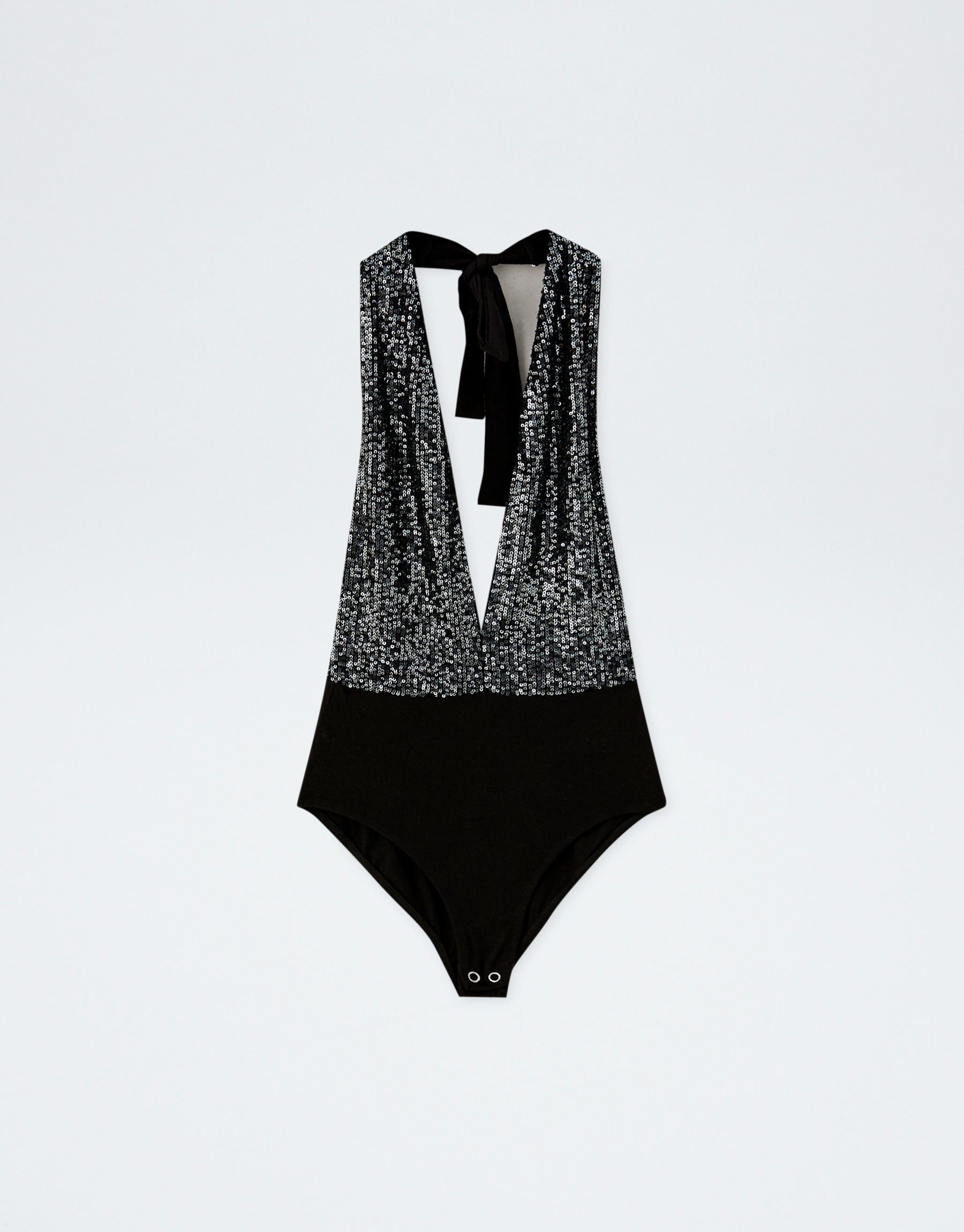 Luce escotazo con este body de lentejuelas atado al cuello de Pull&Bear. (17,99 euros).