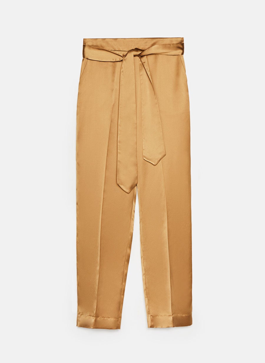 Pantalón satinado en tono dorado de Uterqüe para darle color a tu look de Nochevieja. (69 euros).