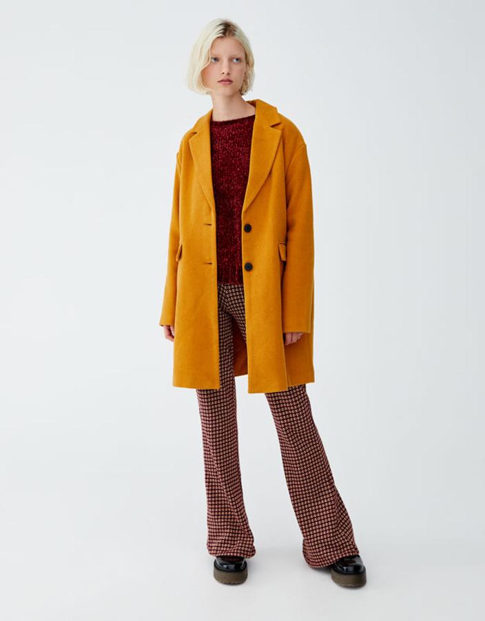 Abrigo básico de paño en color mostaza, 39,99 euros.