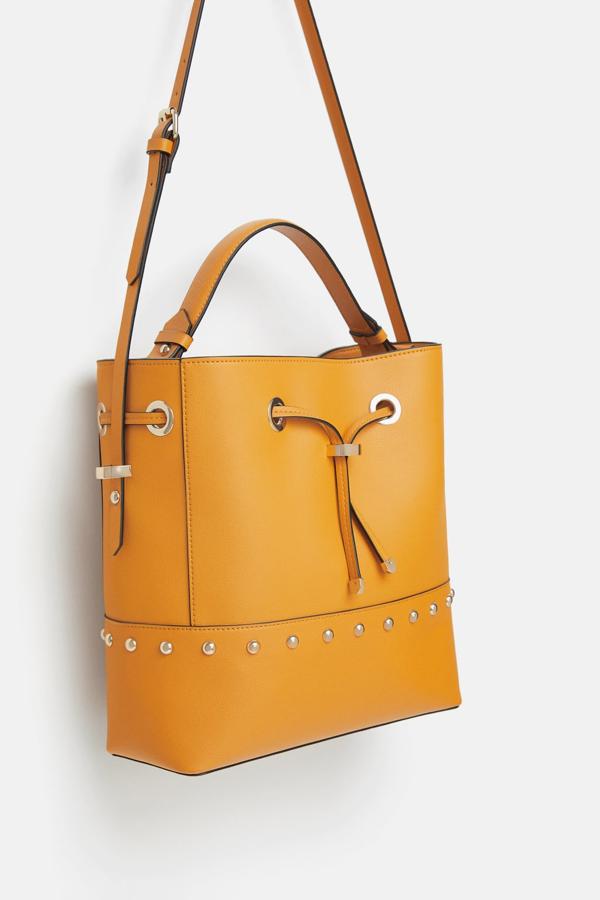 Este bolso tipo saca en amarillo con detalle de tachuelas lo puedes llevar de mano, o colgado al hombro, aportará un toque de color genial al look y, además, solo cuesta 15.99 euros en los 'Special Prices' de Zara.