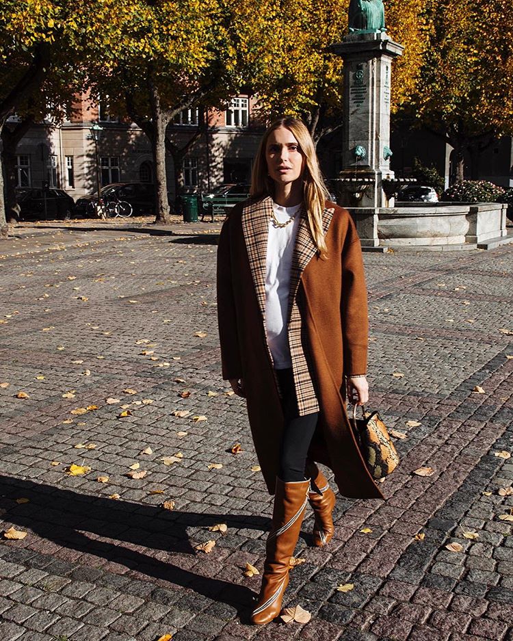 Los abrigos de corte masculino son tendencia esta temporada. La influencer Pernille Teisbaek combina perfectamente este de Mango con una camiseta blanca básica, unos pantalones negros y unas botas camel a juego. Le da un toque chic con el mini bolso animal print, también de Mango.
