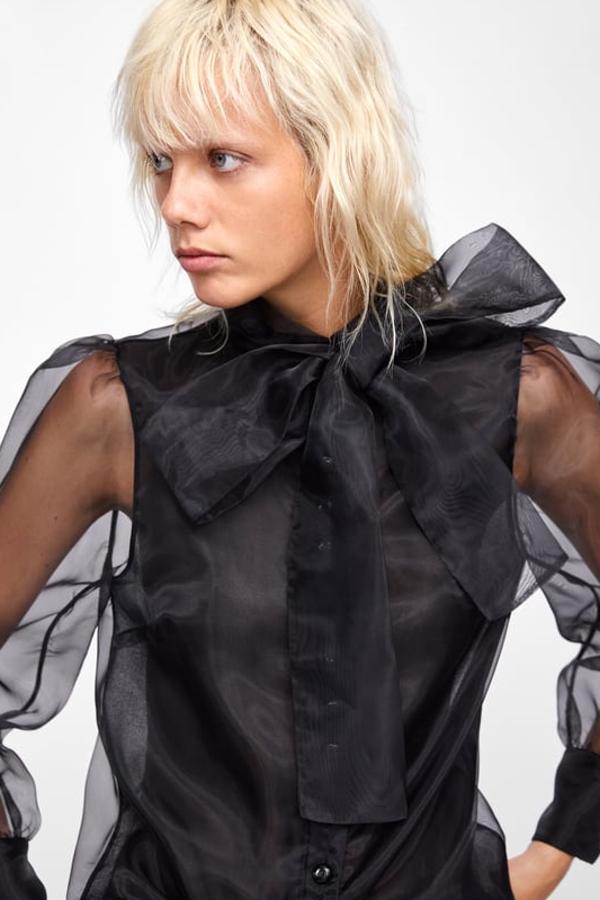 Blusa semitransparente de cuello subido con lazo del mismo tejido y manga larga abullonada (Zara, 39,95 euros).