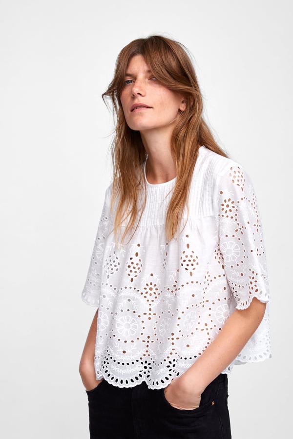 Con cuello redondo y manga corta con acabados en ondas. Lleva unos frunces en el pecho y cierra con un botón en la espalda (Zara, 29,95 euros).