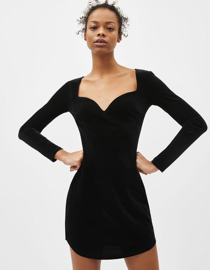 Vestido corto de terciopelo, con escote corazón, manga larga ajustada y cierre en espalda mediante botón (19,99 euros).