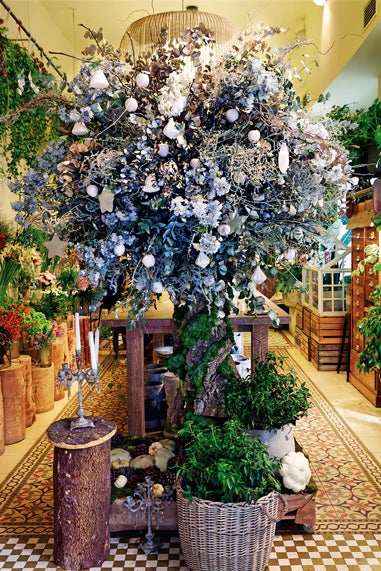 Su inspiración: "He recreado un bosque helado, con un brillo mágico, como el de los cuentos".Su propuesta: "Un árbol decorado con elementos plateados y blancos, elaborado con una base de corteza natural y musgo, ramajes, eucalipto, ramas de magnolio, abedul, esparraguera preservada, manzanas blancas y bolas de cristal. Blanco y plata casi no se utilizan en nuestro país, pero me gusta romper con el colorido tradicional. Estará perfecto en un hall grande o en un patio interior".Combínalo con... "Porcelana blanca alemana en la mesa y adornos en forma de prismas de cristal". Una alternativa: "Si pones flores entre las ramas, parecerá que ha florecido. Las pequeñas flores blancas de la paniculata parecerán copos de nieve". mossfloristas.com.