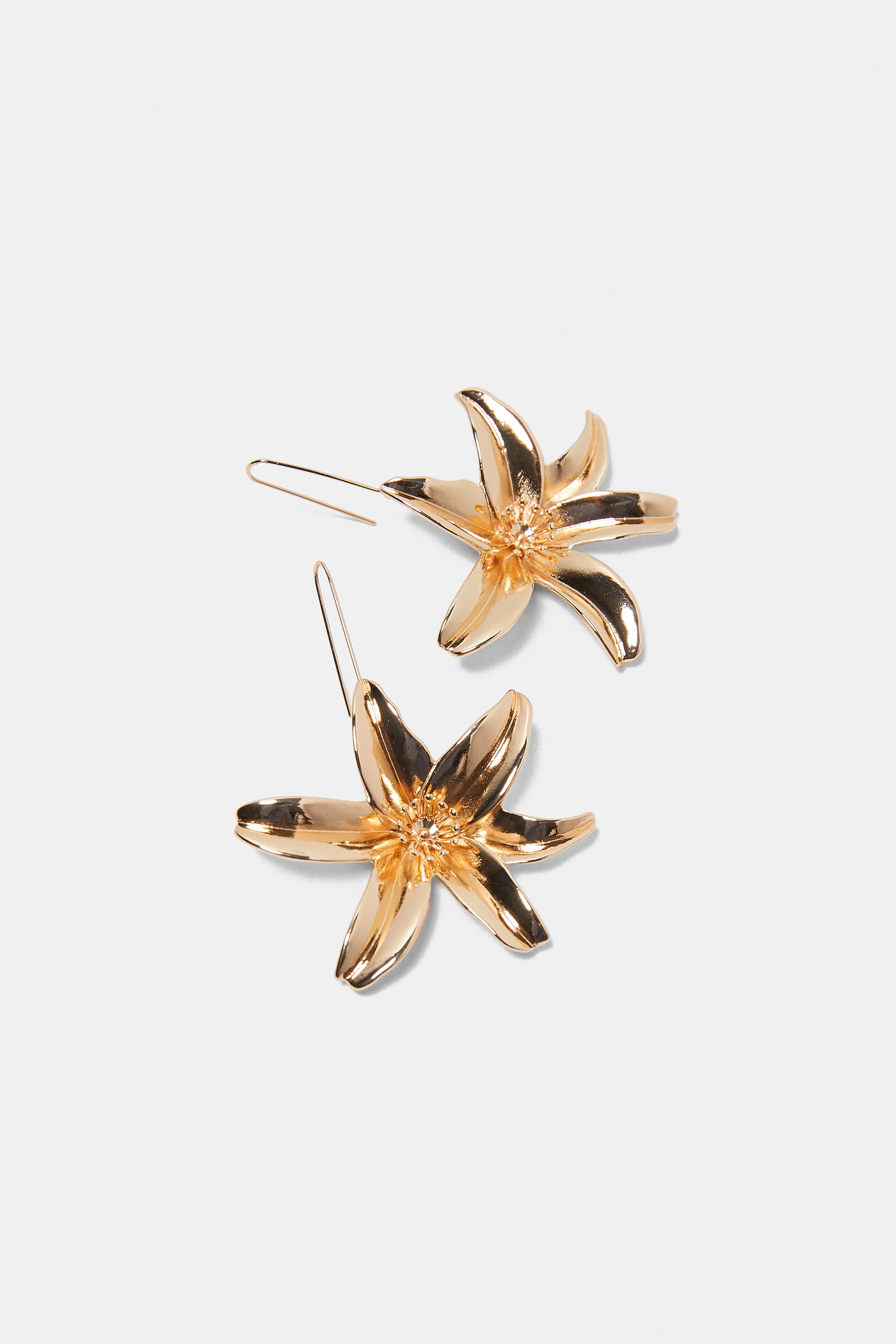 Pendientes metálicos con forma de flor de Zara: 9,95 euros.