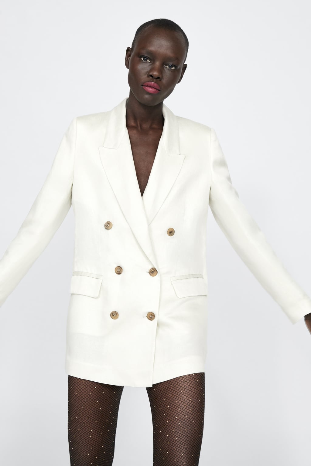 Blazer de lino satinado de Zara, con botones y abertura en la espalda.