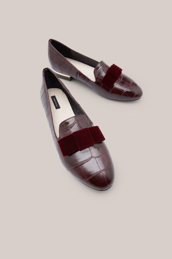 Y estos 'loafers' efecto piel con detalle de lazo de terciopelo nos parecen un chollo: pasan de 69.99 a 39.99 euros en las rebajas de Cortefiel.