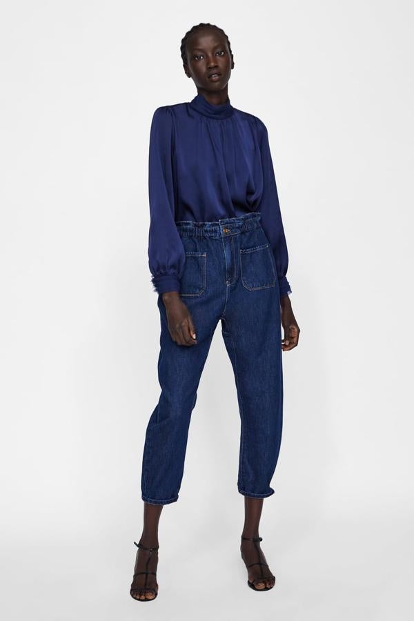 Fantástica blusa con cuello alto, manga terminada en un puño decorado, pliegues desde el cuello y cierre a la espalda (Zara, 25,95 euros).