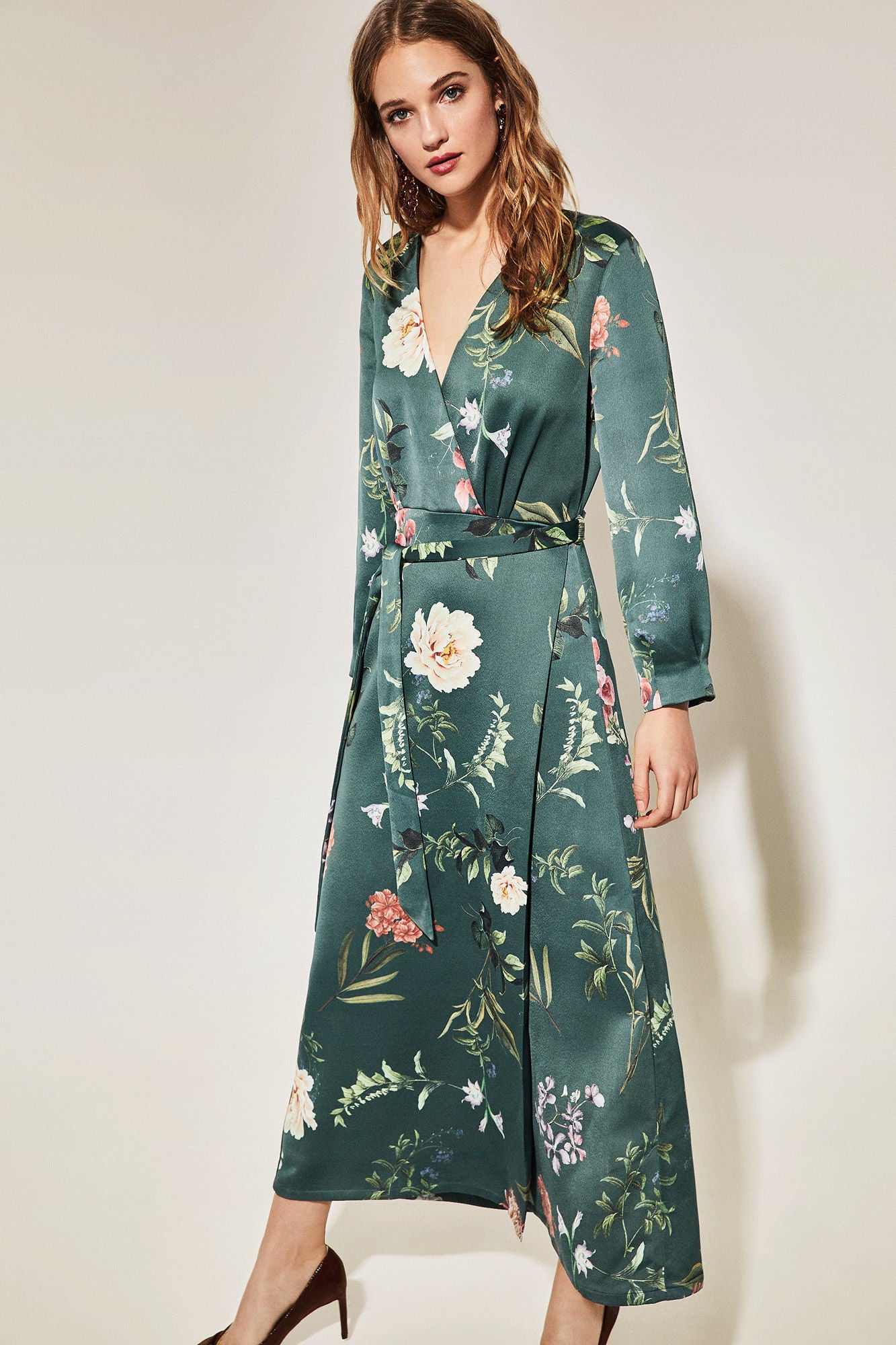 En Cortefiel encontramos este 'wrap dress' en satén verde con estampado floral rebajado de 99.90 a 39.99 euros.