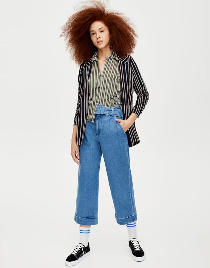 Otra mezcla fantástica que combina unos vaqueros con la pernera ancha y cinturón (29,99 euros) con dos estampados de rayas totalmente distintos: los de la americana fluida en blanco y negro y las de la camisa en tonos verdes y beis. Ambas prendas están por llegar a tienda.