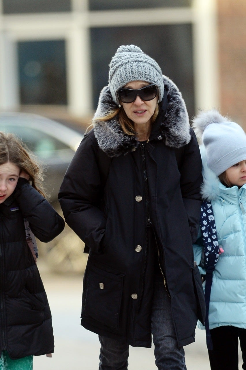Sarah Jessica Parker apuesta por una parka de color negro con capucha de pelo. Es el  abrigo favorito de algunas famosas españolas  como Blanca Suárez o Laura Escanes.