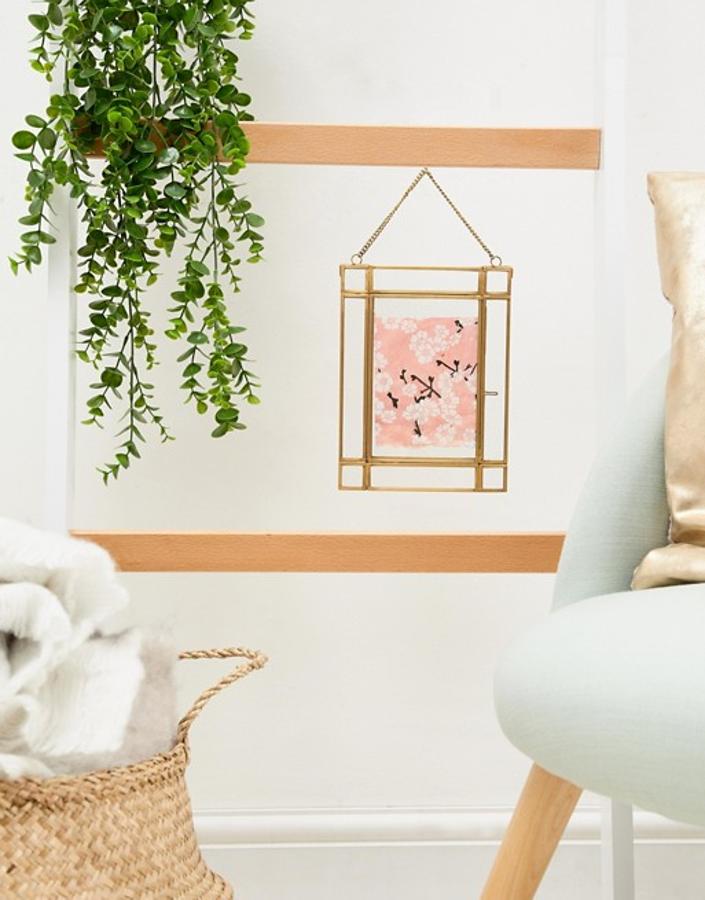 Este marco de fotos en color dorado e inspiración 'retro' está rebajado a 11.49 euros en la sección de decoración de Asos.