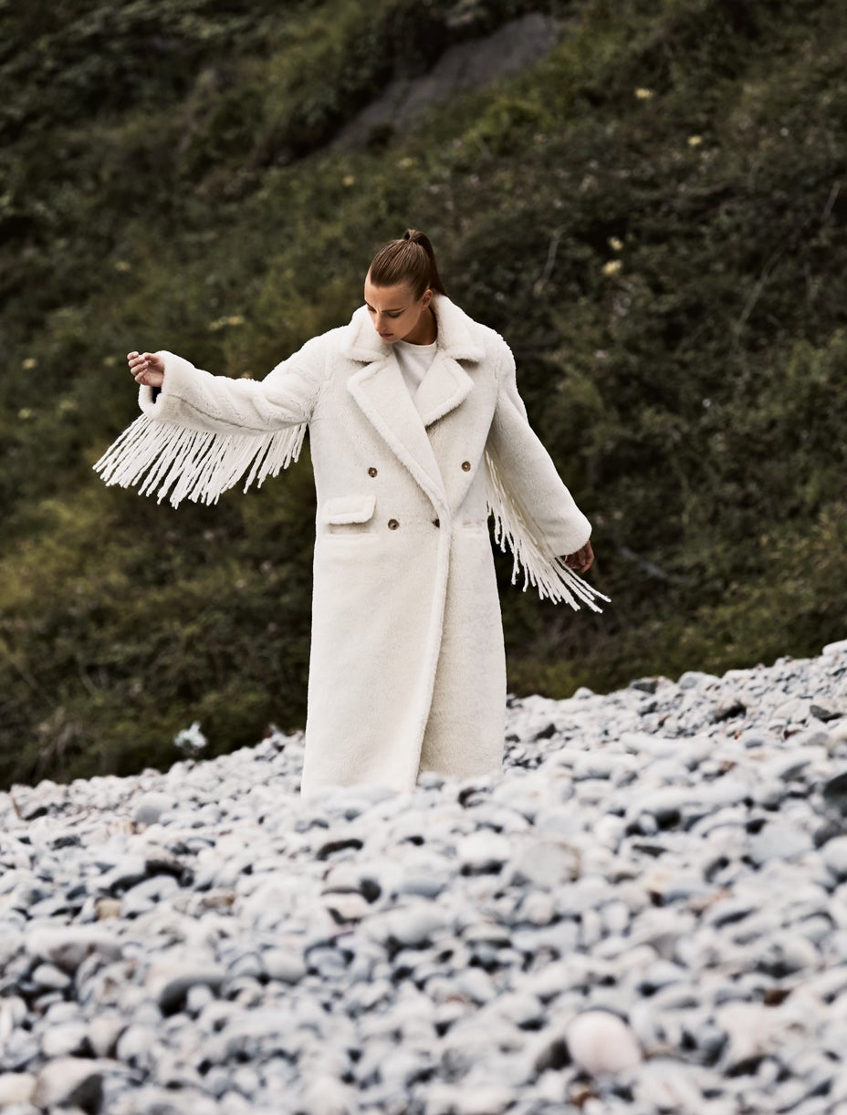 Abrigo con flecos de Max Mara y top de El Corte Inglés.