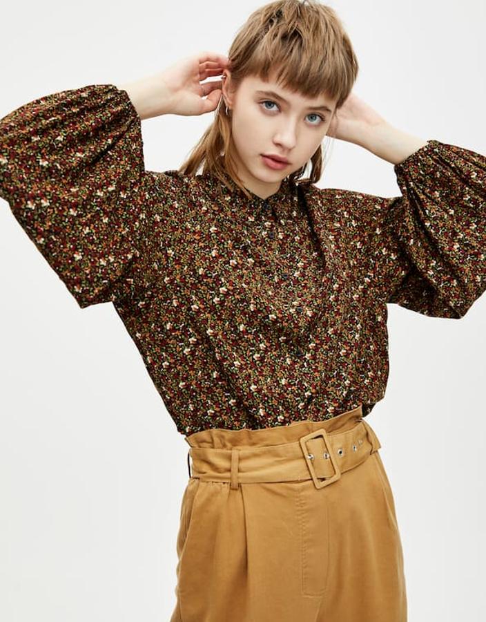 Camisa de flores con mangas abullonadas, cuello camisero, cierre de botones y lazada en el bajo (19,99 euros).