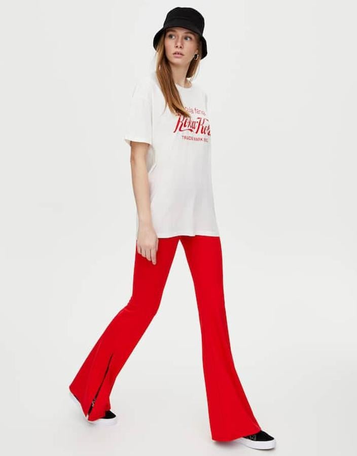 Pantalón campana con aberturas laterales a la altura del bajo, cintura con trabillas y costura de cremallera simulada (17,99 euros).