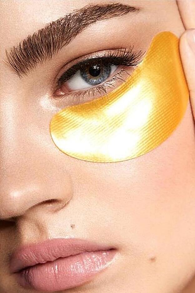 Detalle de la aplicación de un parche de tratamiento en el contorno del ojo.