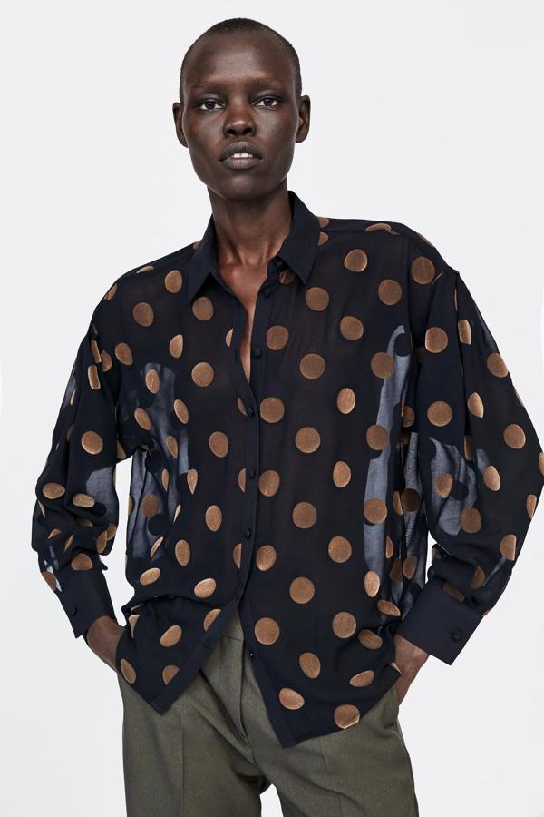 No puede ser más elegante esta blusa de terciopelo negro con lunares dorados. Nos la pondríamos de la mañana a la noche, y aún está disponible en todas las tallas en Zara por 25.95 euros.