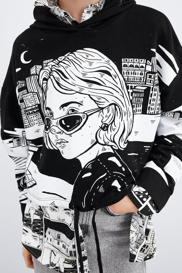 Sudadera corta con capucha ajustable, manga larga y bajo con cordón ajustable. Lleva una estampación en el frontal obra de Ana Müshell (22,95 euros).