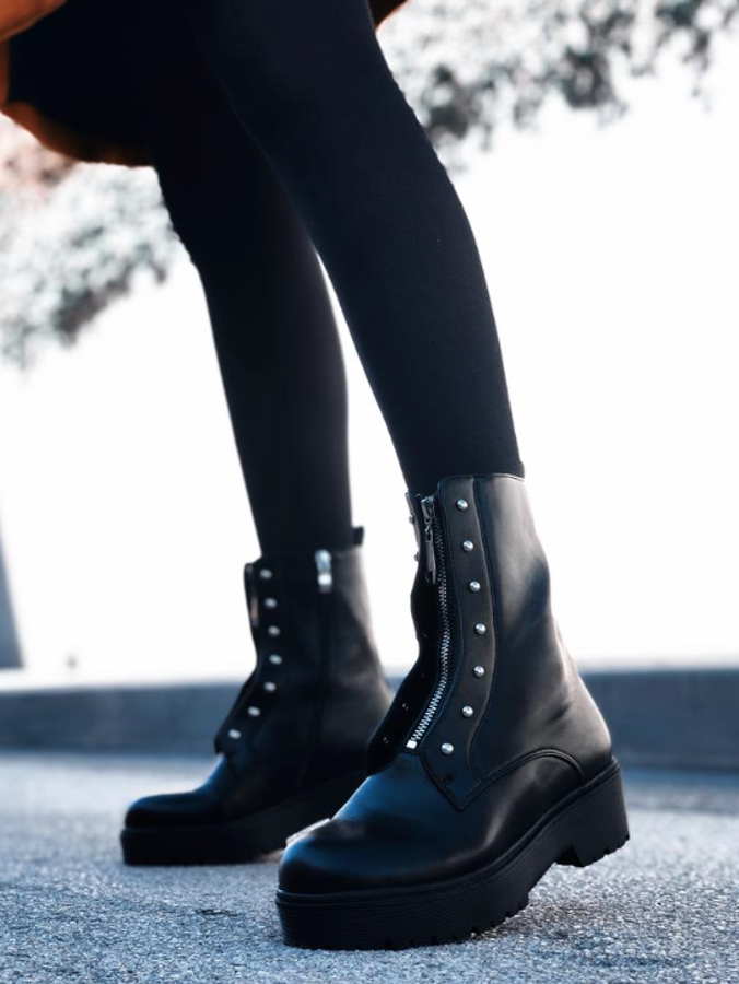 Botas negras con tachuelas, adornadas con una cremallera delantera decorativa y otra lateral para el cierre. La altura del tacón es 4 centímetros y la del corte, 17 centímetros.