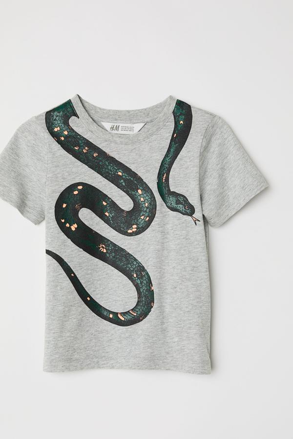 Esta camiseta gris de manga corta con dibujo de serpiente es de  H&M . Cuesta  9,99 euros  y la tienes disponible también con la serpiente en colo azul.