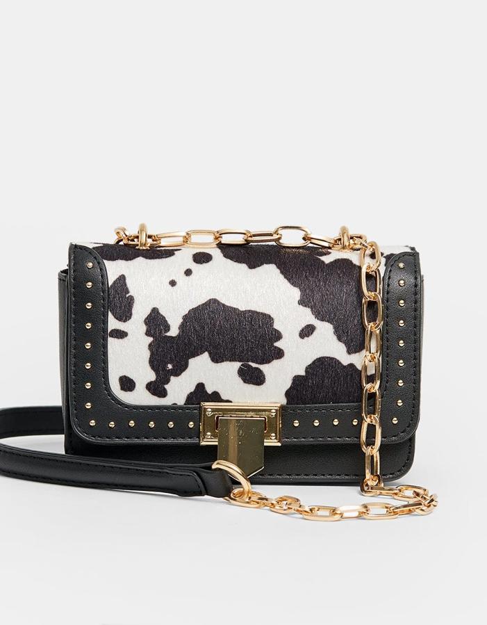 Los acesorios tampoco se resisten a este estampado y este bolso de bandolera con "print" de vaca y detalles de tachuelas lo confirma.