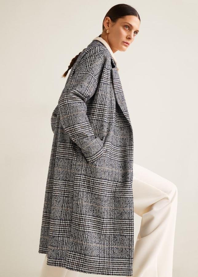 Diseño largo en tejido mezcla de lana estampado a cuadros, con cuello de solapa, manga larga y dos bolsillos laterales. lleva un abertura posterior, forro interior y cierre de clip (Mango, 49,99 euros).