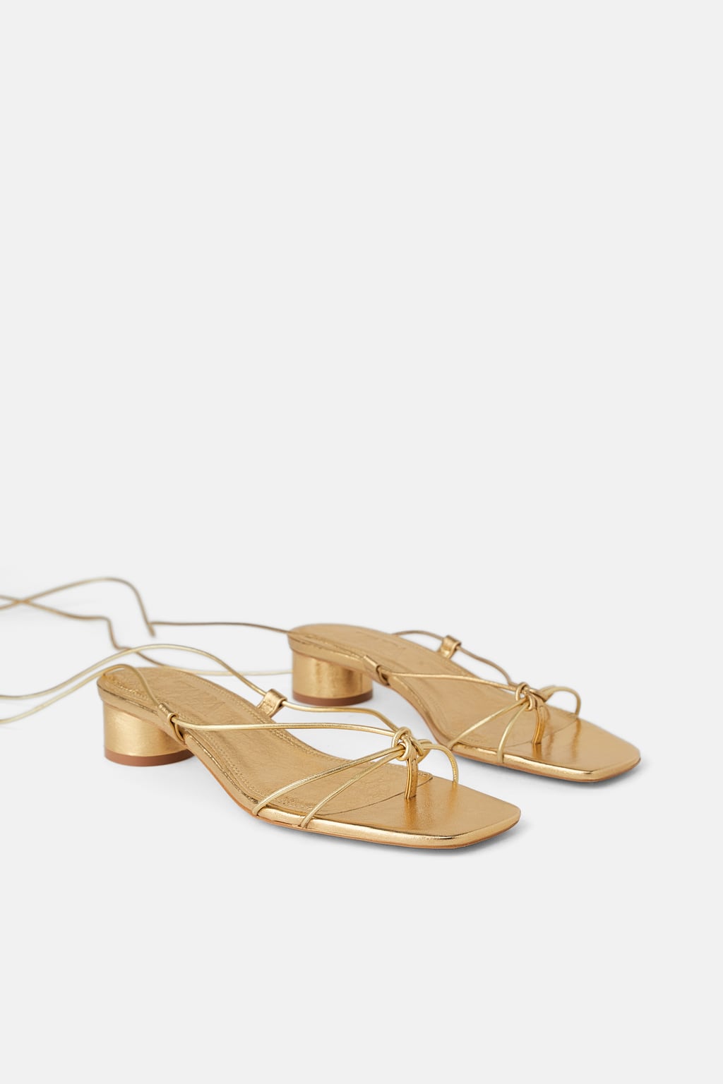 Sandalia de tacón con finas tiras en color oro: 39,95 euros en Zara.