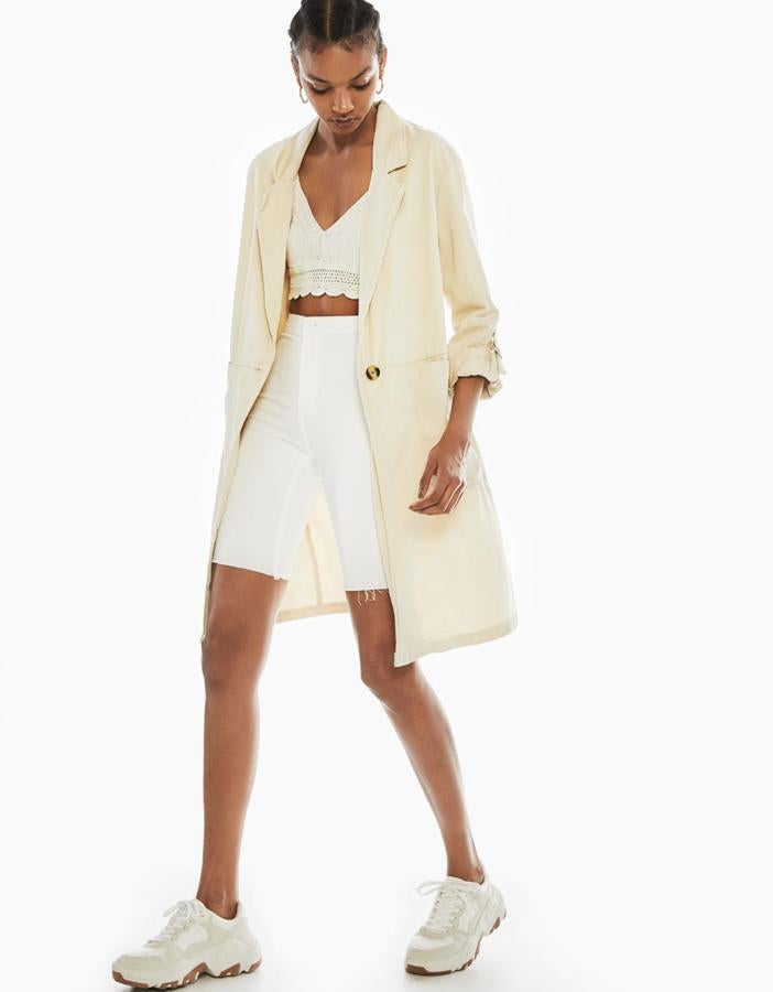 Trench ligero confeccionado en Tencel, un textil procedente de madera extraída de bosques sostenibles. Lleva cuello de solapa, manga 3/4 con vuelta sujeta por trabilla y dos bolsillos delanteros (Bershka 39,99 euros) .