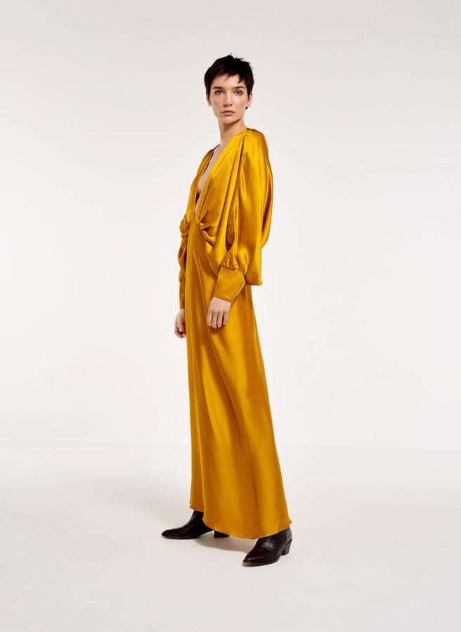 Vestido largo de raso en color mostaza, con mangas abullonadas, 179 euros.